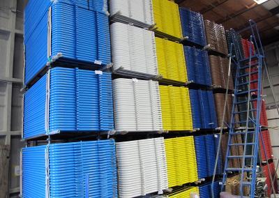 Painted steel barriers stacked in warehouse